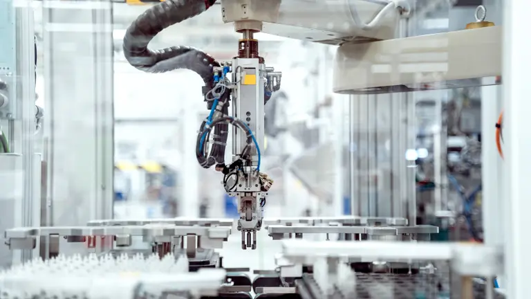An automated production line with robotic arms processing parts on conveyor belts.