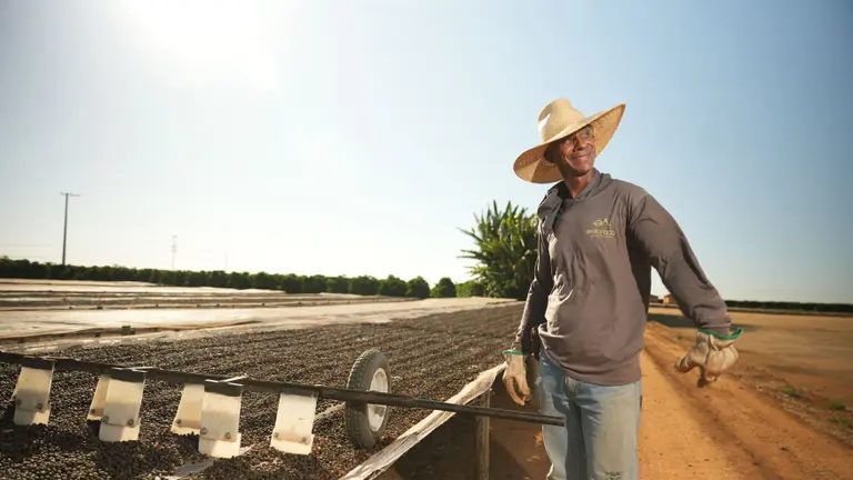 A man standing on a field in the sun, working