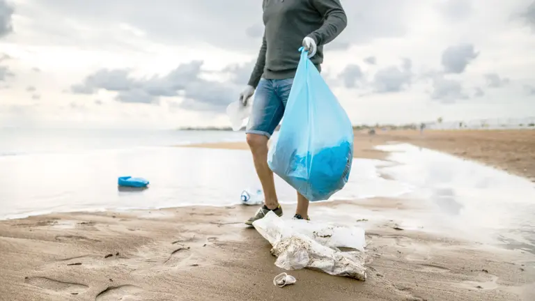 Man collection trash on the beach