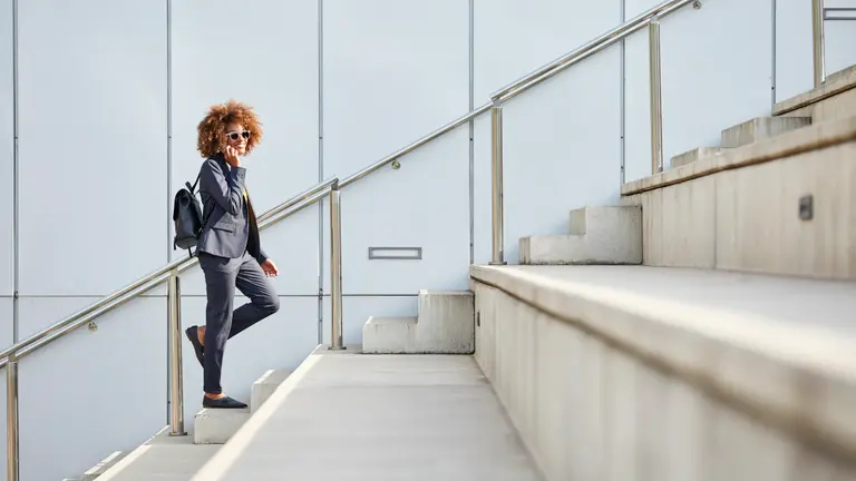 A woman talking on the phone while walking up the stairs